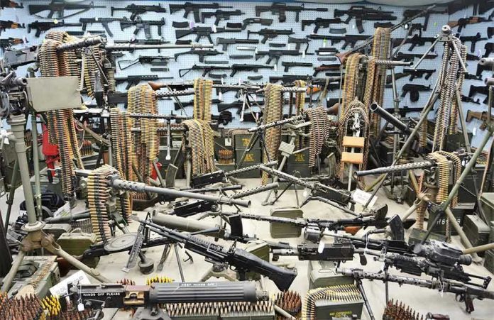 1967096365 Room filled with various firearms and ammunition belts