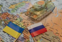 Toy tank on map with Ukraine and Russia flags.