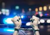 Handcuffed hands raised police cars with lights on