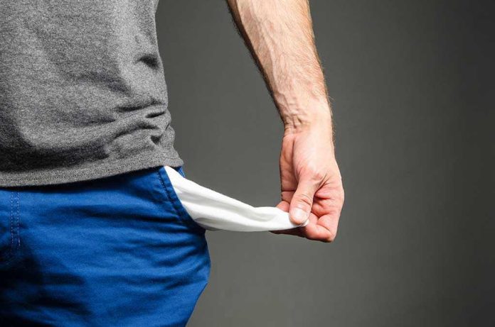 Person pulling out empty pocket from shorts
