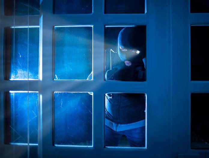 514808032 Masked figure peering through glass door at night.