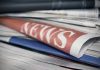 Stack of newspapers with "NEWS" headline visible.