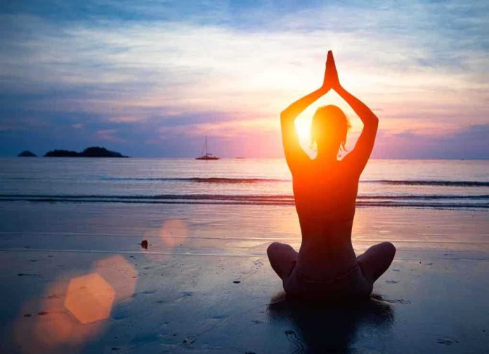 shutterstock_126464135.jpg Person meditating on the beach during sunset