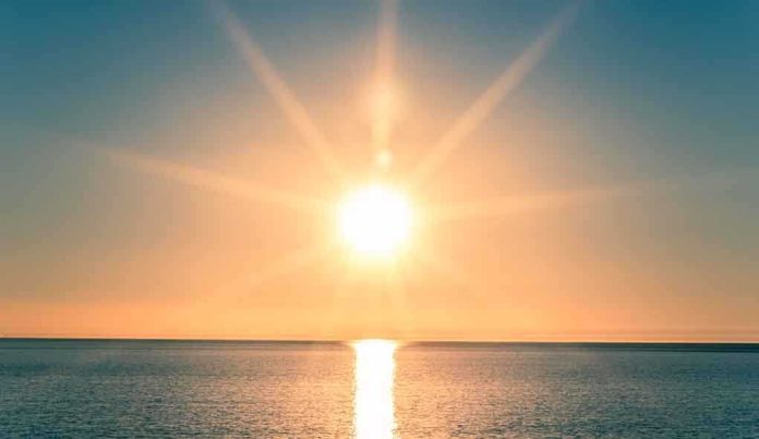 shutterstock_242372626.jpg A serene sunrise over a calm ocean with vibrant colors in the sky
