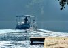 Two people on a boat navigating a misty lake