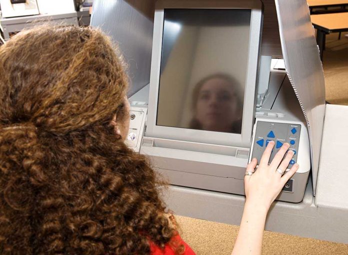 shutterstock_10042039.jpg A person using an electronic voting machine at a polling station