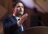 Rubio SLASHES Dept — Diplomatic Earthquake Begins A man in a suit delivering a speech at a podium