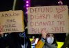 No Kings Protest — Real Uprising or Massive Hoax? Two individuals holding protest signs with messages about police reform