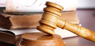 Rare Titanic List Found—Auction Price Shocker! A wooden gavel resting on a circular base with law books in the background