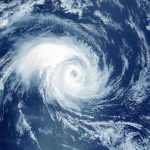 Mass Evacuation—Millions Flee Monster Storm Satellite image of a swirling hurricane over ocean.