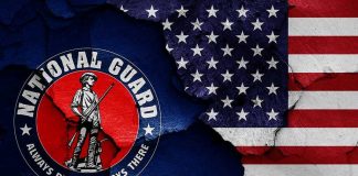 Guard Members GUNNED DOWN – Sparks IMMEDIATE Blame Game National Guard logo over a distressed American flag.