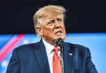 Trump Targeted: Mamdani Fires WARNING SHOT! Man in suit speaking at a microphone.