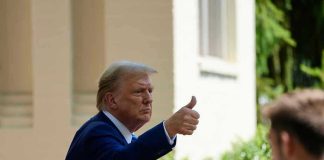 Man in suit giving thumbs up.