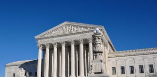 The Supreme Court building with large columns and a clear blue sky