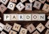 Trump FREES $1.6 Billion Fraud King – Days into Sentence Wooden letter blocks arranged to spell 'PARDON' on a wooden surface