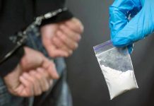 Fentanyl Chaos Hits Providence College Party Person handcuffed, police holding bag of white substance.
