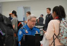 Airport ASSAULT: Attacker SLAMS TSA Agent, Federal Charges Filed TSA agent checks passengers documents at airport security.