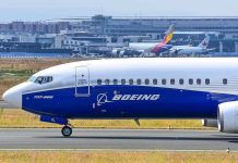 Boeing 737-800 on airport runway with other planes.