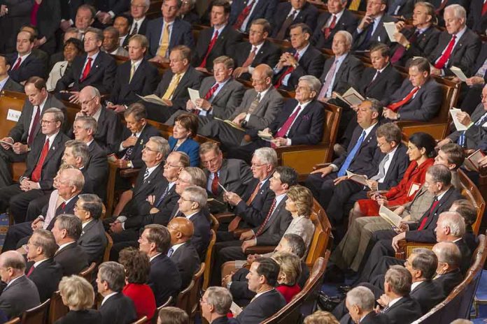 492045043 Audience of officials sitting and reading documents in auditorium.