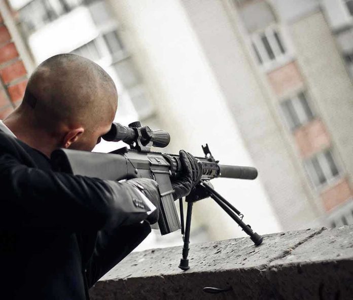 555247681 Person aiming a rifle from a building balcony.
