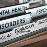 File folders labeled with mental health disorders and psychiatry.