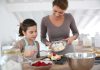 A mother and daughter baking together in a bright kitchen