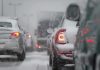 Cars stuck in traffic during a snowstorm with snow covering the vehicles