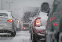 Cars stuck in traffic during a snowstorm with snow covering the vehicles