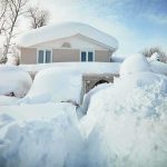 A house surrounded by deep snow drifts after a heavy snowfall