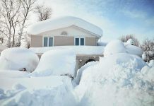 A house surrounded by deep snow drifts after a heavy snowfall