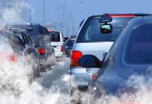 Traffic jam with cars emitting exhaust fumes on a city road