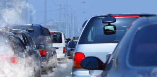 Traffic jam with cars emitting exhaust fumes on a city road