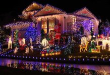 A house decorated with colorful Christmas lights and festive figures