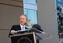 Maher STUNNED When Woke Liberal Breaks Ranks A man in formal attire speaking at a podium during a Hollywood Walk of Fame ceremony