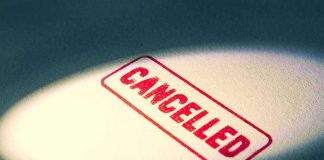 Red Cancelled stamp under a spotlight.