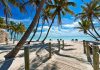 Tropical beach with palm trees and clear blue water