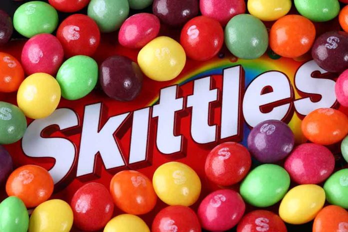 A colorful assortment of Skittles candies surrounding the Skittles packaging