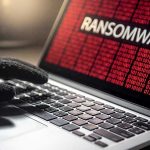 Ransomware FREEZES Mississippi Medical Network Gloved hand on laptop with ransomware screen.