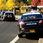 ACTIVE SHOOTER Chaos Erupts At School Police cars and school buses on a road.