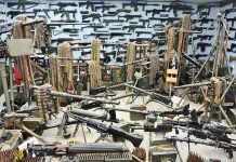 Room filled with various firearms and ammunition belts.