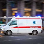 Ambulance STOLEN With Patient Strapped Inside Ambulance driving on urban street with lights flashing.