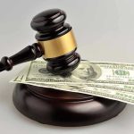 Catholic Diocese CRUMBLES – $180M Settlement Gavel resting on hundred-dollar bills.