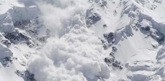 An avalanche occurring on a snowy mountain slope