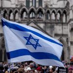Israeli Flag Planted In Syrian Town Israeli flag at a crowded outdoor event.