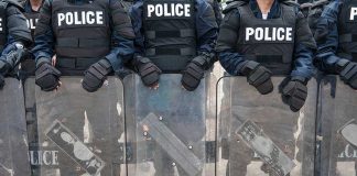 Masked Agitators CRUSHED at ICE Gate Police officers in riot gear holding shields.