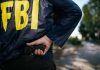 Man Hurls Stolen Bones Over FBI Fence FBI agent holding a gun behind the back.