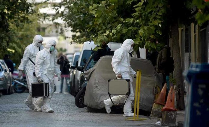 779710051 Investigators in hazmat suits carrying equipment cases.