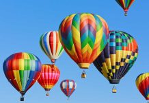 Balloon Passengers Trapped On Swaying Tower Colorful hot air balloons floating in a clear blue sky
