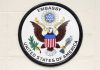 Seal of the United States Embassy featuring an eagle and the American flag