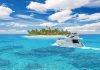 A luxury yacht cruising in clear blue waters near a tropical island